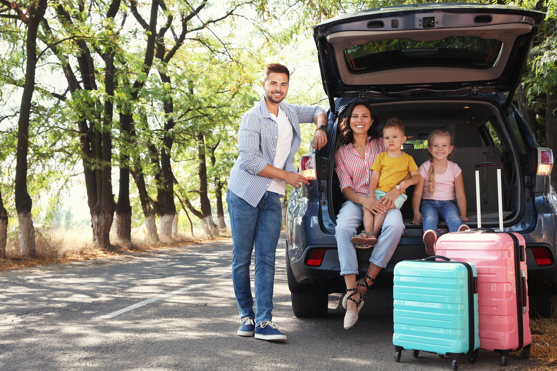 familie-am-auto-mit-koffern familie-am-auto-mit-koffern